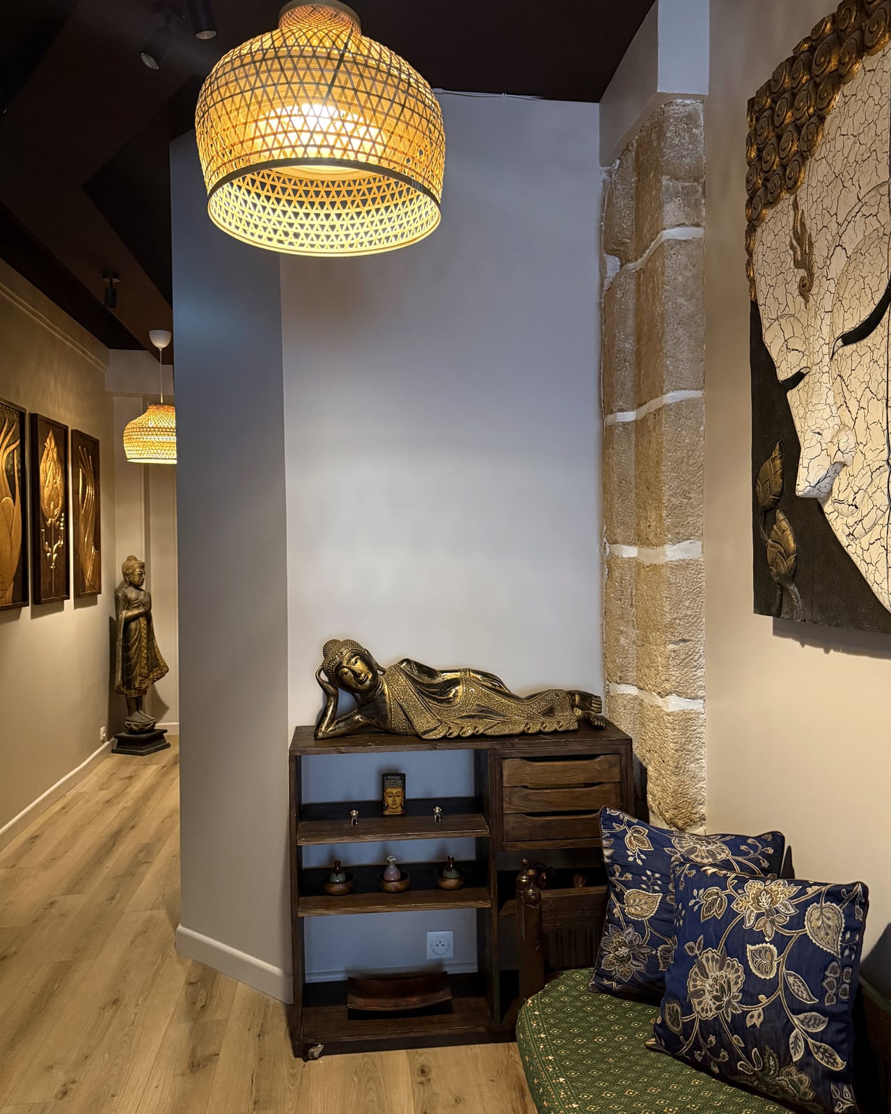 Espace d'accueil HOOM avec Bouddha allongé, assise textile et vue sur le couloir.